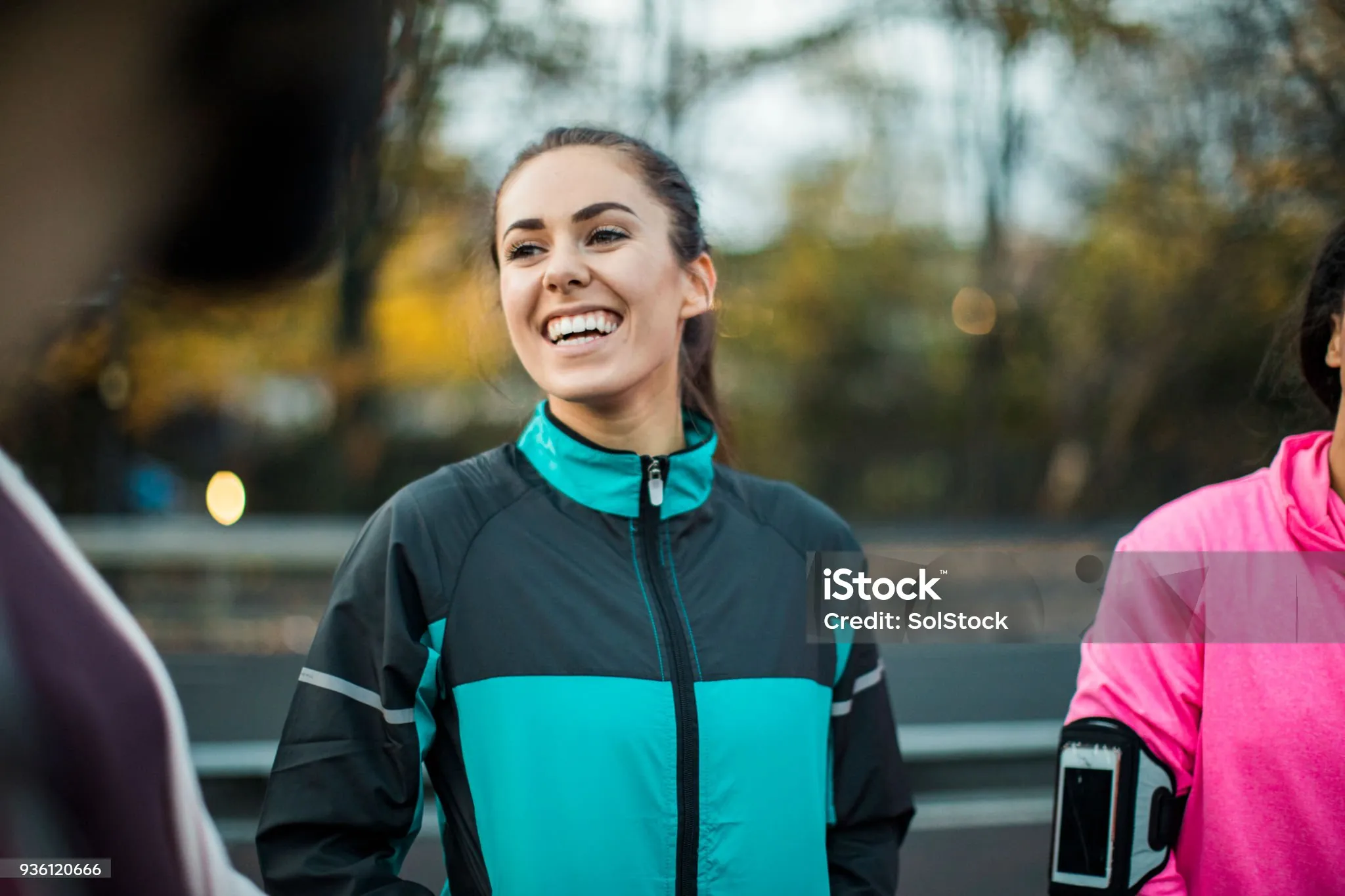 A young woman rests from her run with a running group.